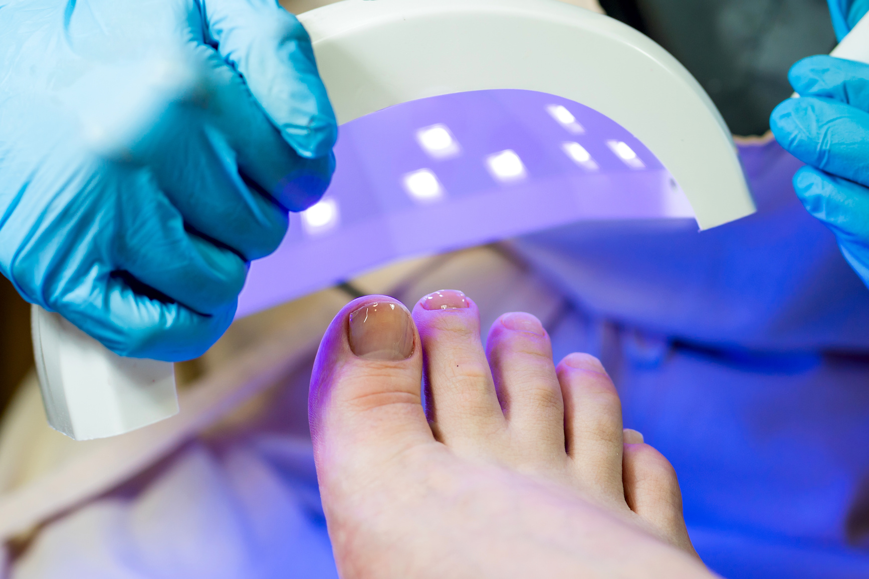 Pedicure. Drying Base Layer under UV Lamp